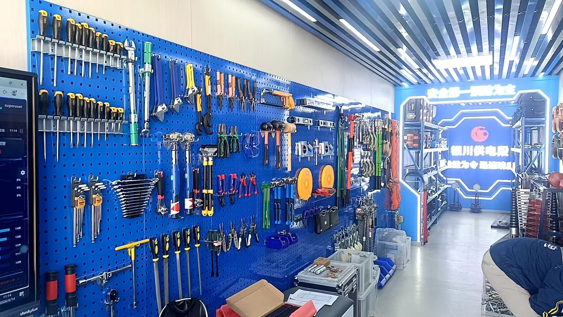 The tool warehouse at a railway power supply section emergency repair base, with blue pegboard workstations and a smart tool wall
